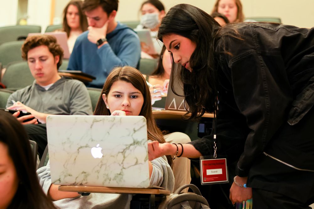 A student helps another student in class.