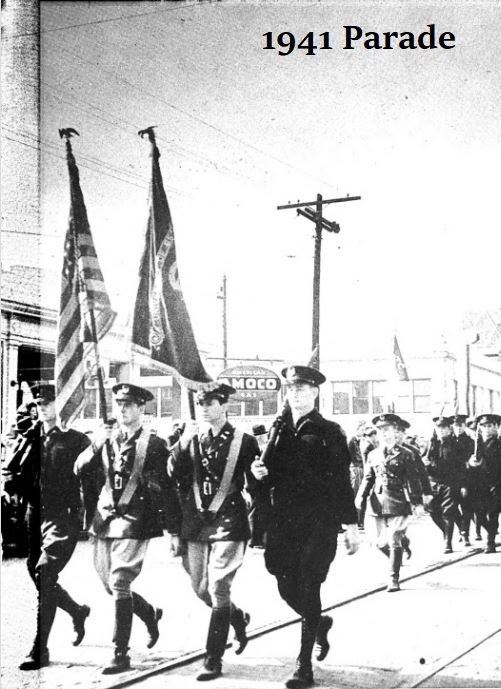 Black and white image of the 1941 Parade with four cadets walking in front in formation holding flags. 