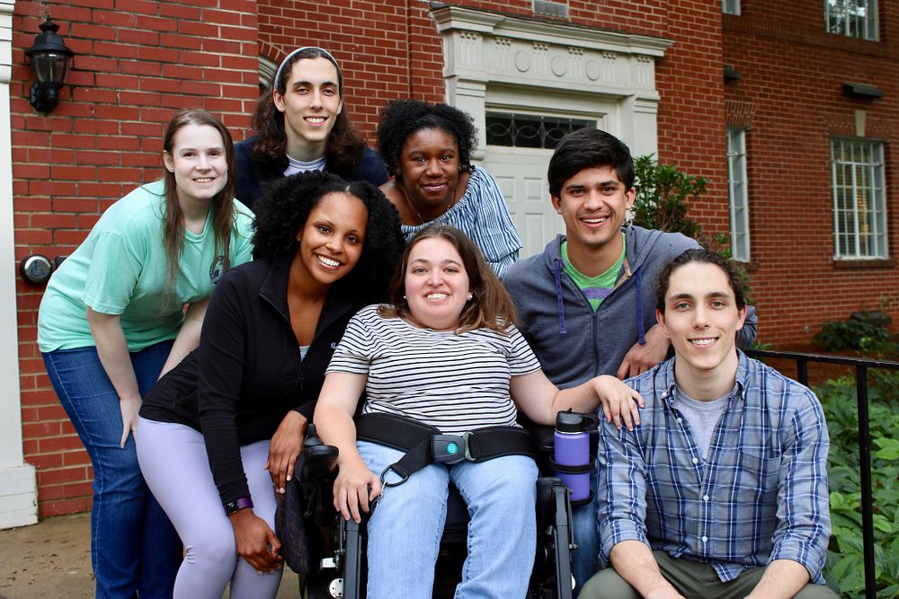 A group of students outside a building. One student is in a wheelchair.