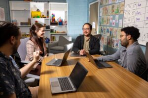 A group of students meet with their professor.