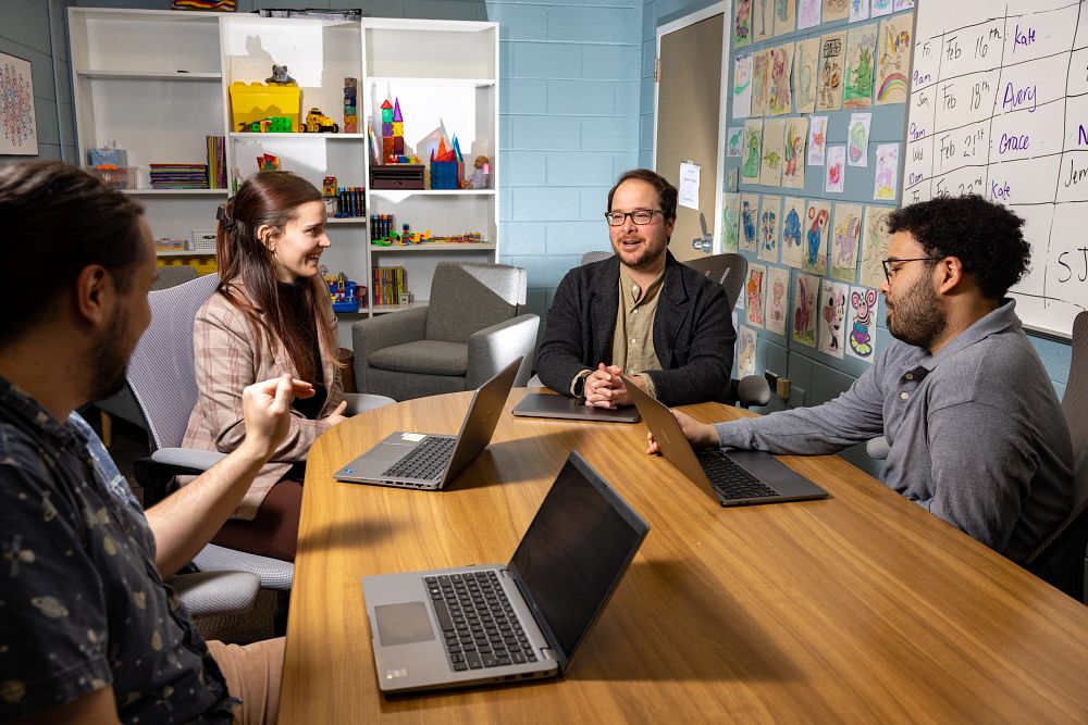 A group of students meet with their professor.