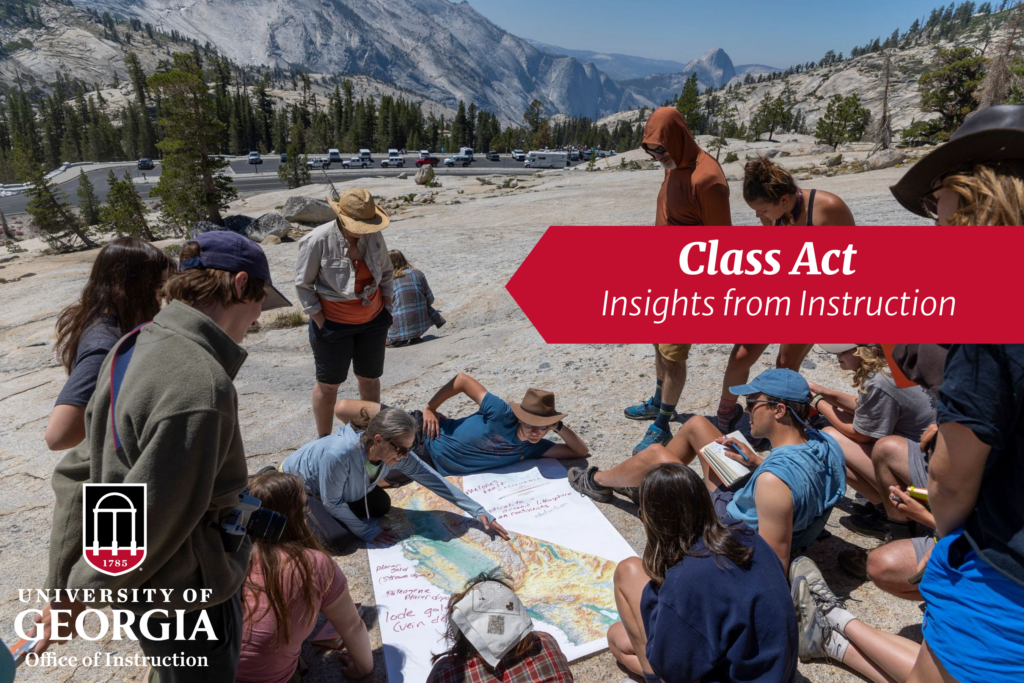 A class is taught outside in the Western U.S. Students look over a map laid out on the rocks while a teacher looks on. in the distance are mountains and a river. 
